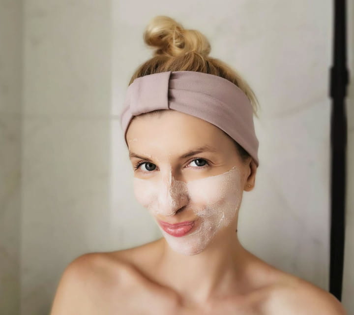 Kobieta z twarzą posmarowaną peelingiem-maską