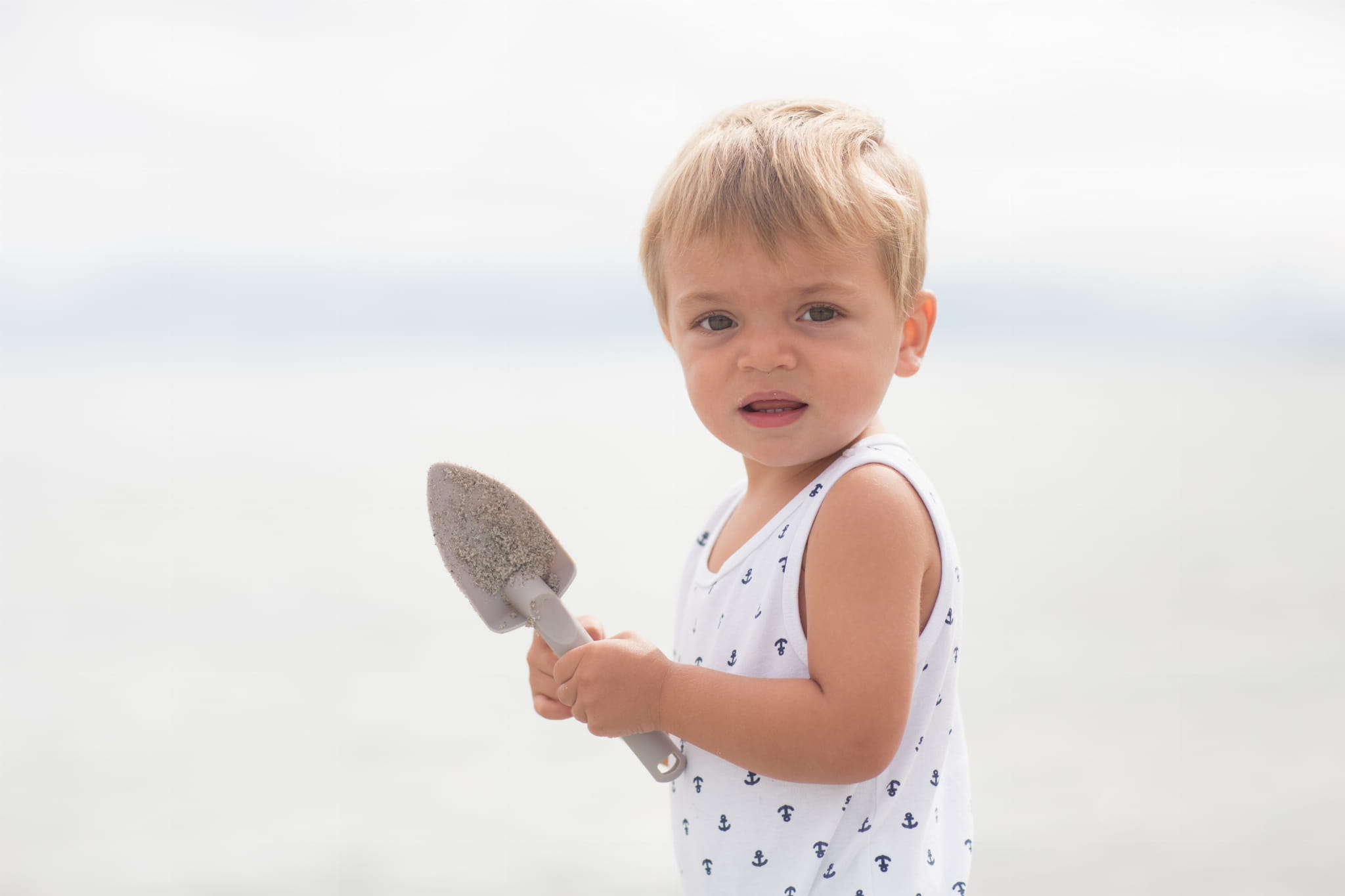Dziecko z łopatką w dłoniach na plaży