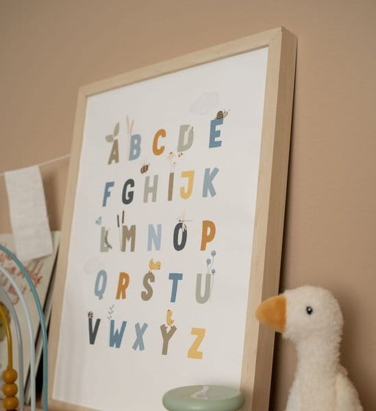 Plakat z alfabetem zamknięty w drewnianych ramach. Obok maskotka gąska