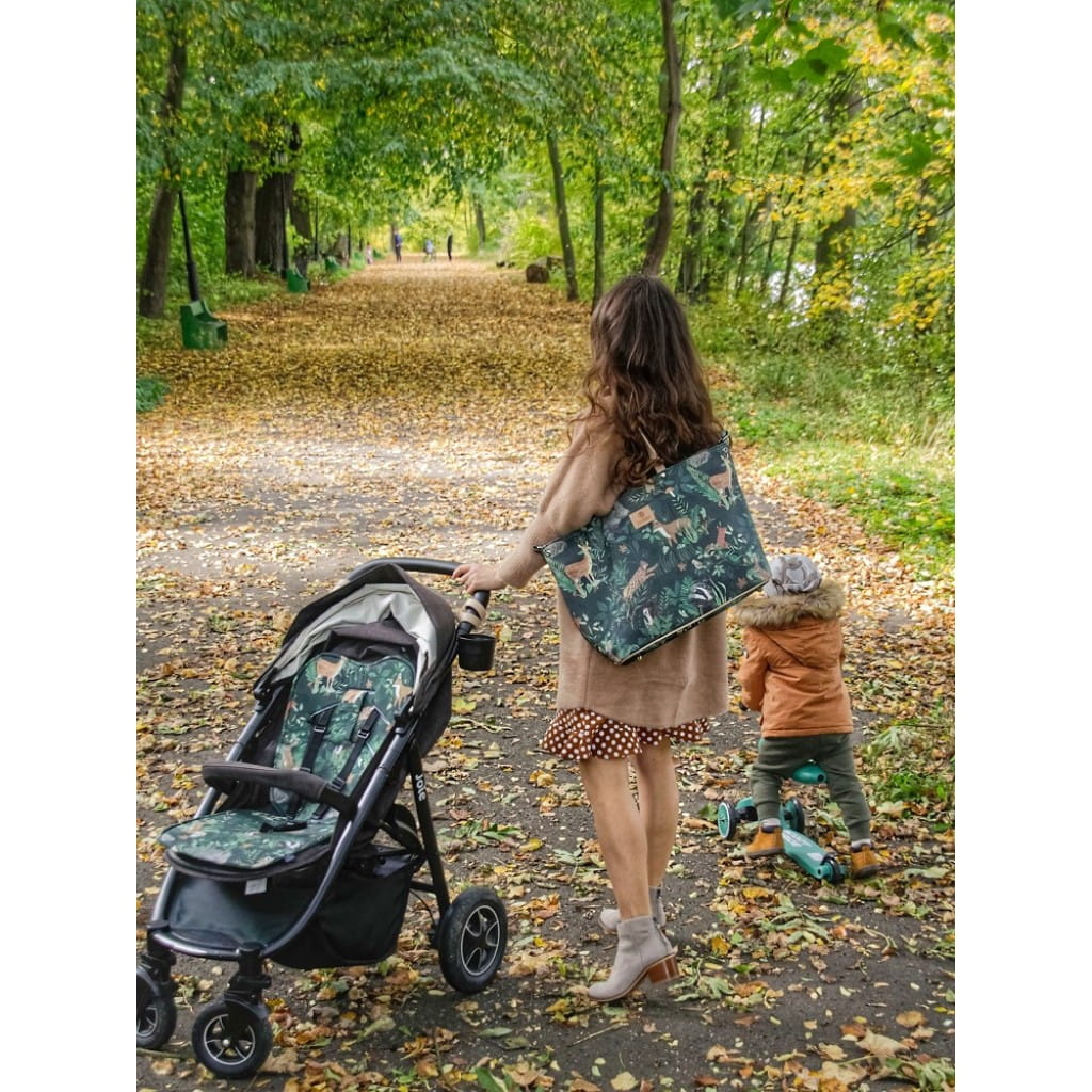 Kobieta z dzieckiem i wózkiem w jesiennej alejce